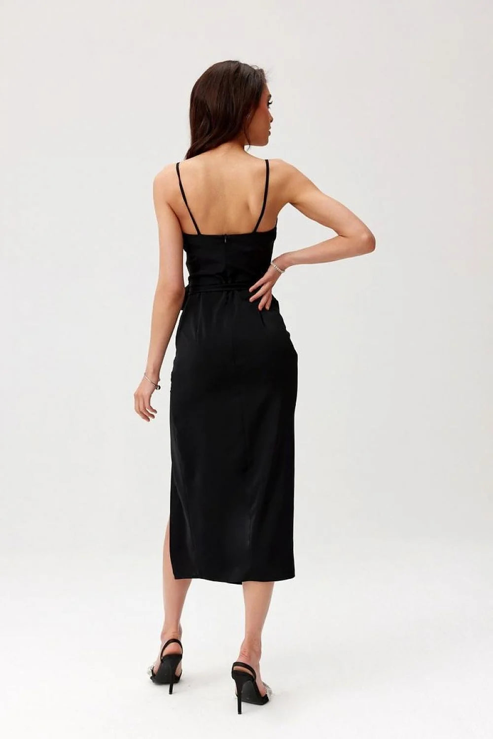 Robe de cocktail élégante noire longueur midi dos nu bretelles fines tissu satiné fente jambe fleur accessoire femme