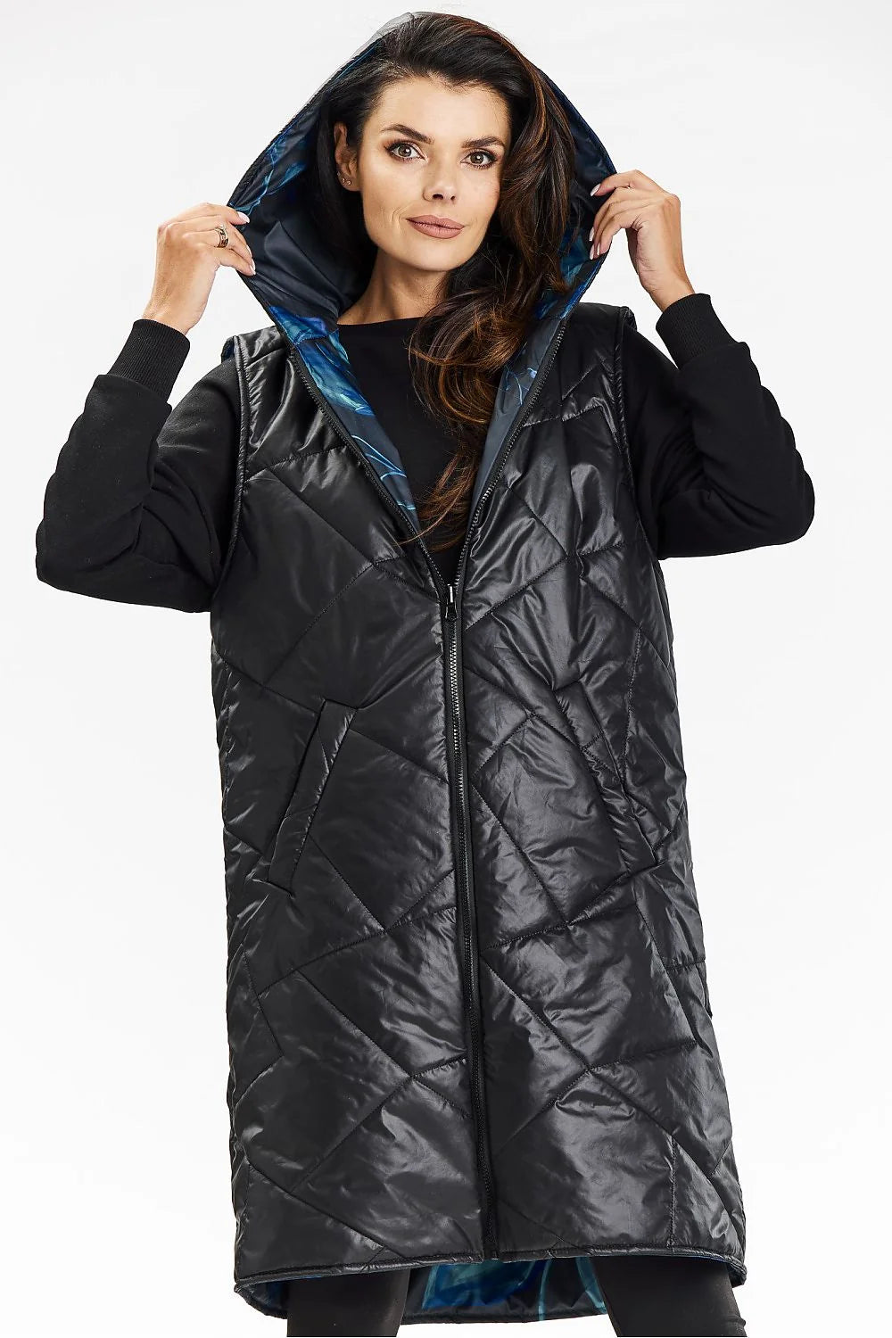 Gilet long sans manches pour femme, design matelassé, capuche intégrée, fermeture éclair centrale, poches latérales, tissu polyester 100%, style moderne et pratique