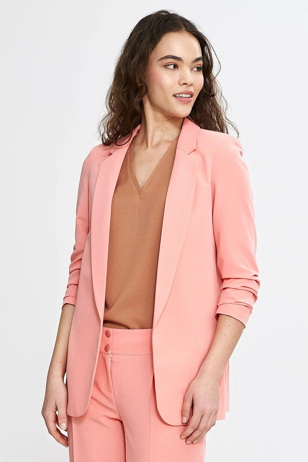 Veste et pantalon coordonnés élégants pour femme en rose saumon, style professionnel et moderne, coupe ajustée, matières confortables, occasions multiples