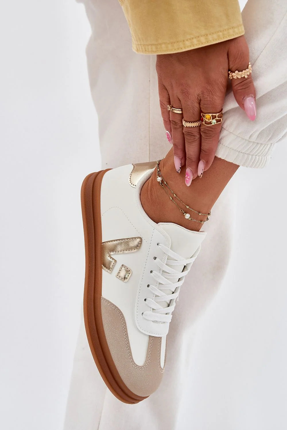 Chaussures de sport Step in style pour femmes, design moderne épuré, cuir artificiel, semelle confortable, style casual, baskets basses, lacets blancs, logo doré, double bracelet perlé, beige et blanc