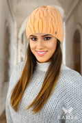 Bonnet féminin tricoté en torsades pêche douce, style classique, coupe ajustée, matériau doux, finitions soignées, logo métallique discret, vêtement hiver, mode intemporelle