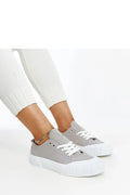 Baskets Adidas grises pour femmes, style moderne, tige basse, toile respirante, semelle caoutchouc, lacets blancs, accessoire chaînette multicolore, sneakers confortables occasionnels, look décontracté et sophistiqué