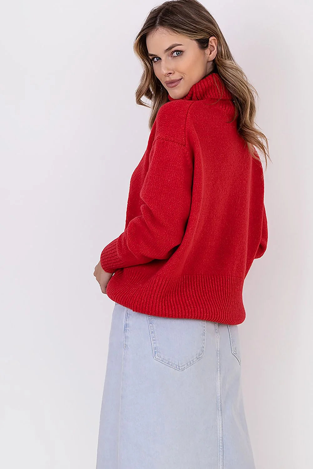 Pull col roulé rouge ample en tricot associé à jupe en denim bleu clair longue fente frontale pour femme