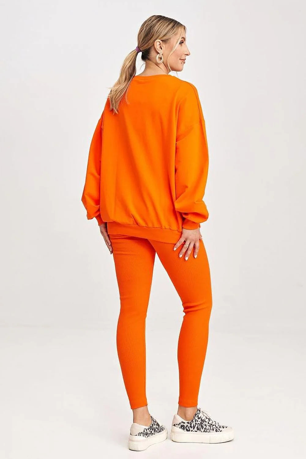 Ensemble sportswear pour femmes, sweatshirt orange, leggings, style casual, confort optimal, vêtement détente, mode moderne, porté quotidien, tenue relax, couleur vif, matière douce, maintien sécurisé, coupe ample, design graphique