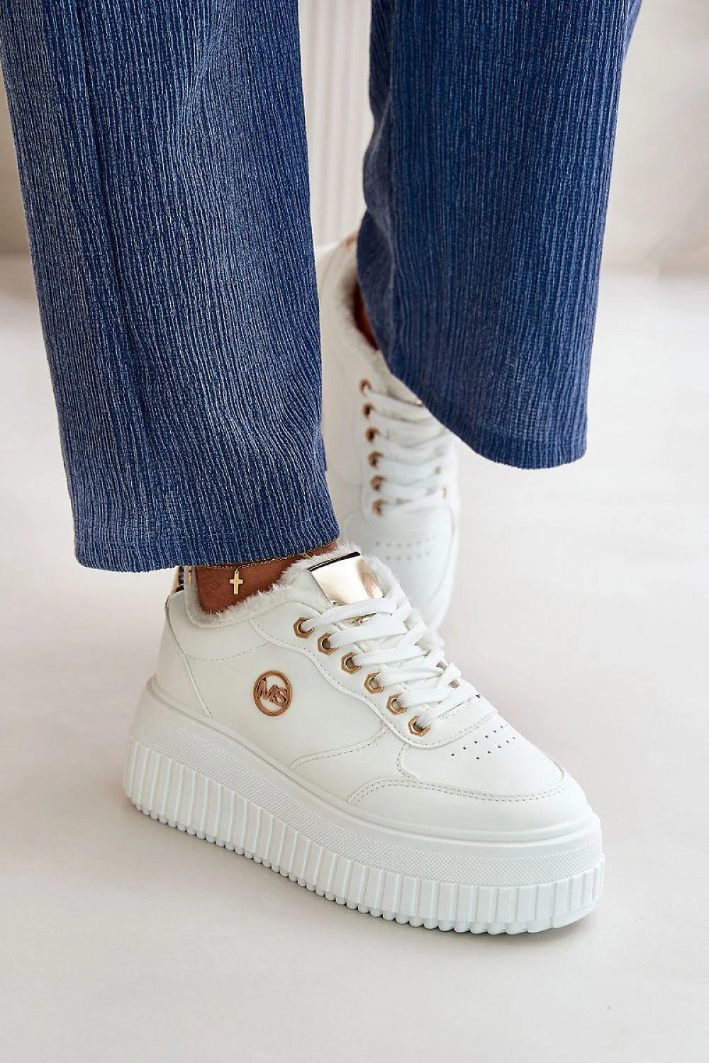 Chaussures de sport féminines modernes en cuir synthétique blanc, semelles compensées, finitions dorées, logo métallique, fourrure intérieure, coupe basse, style polyvalent