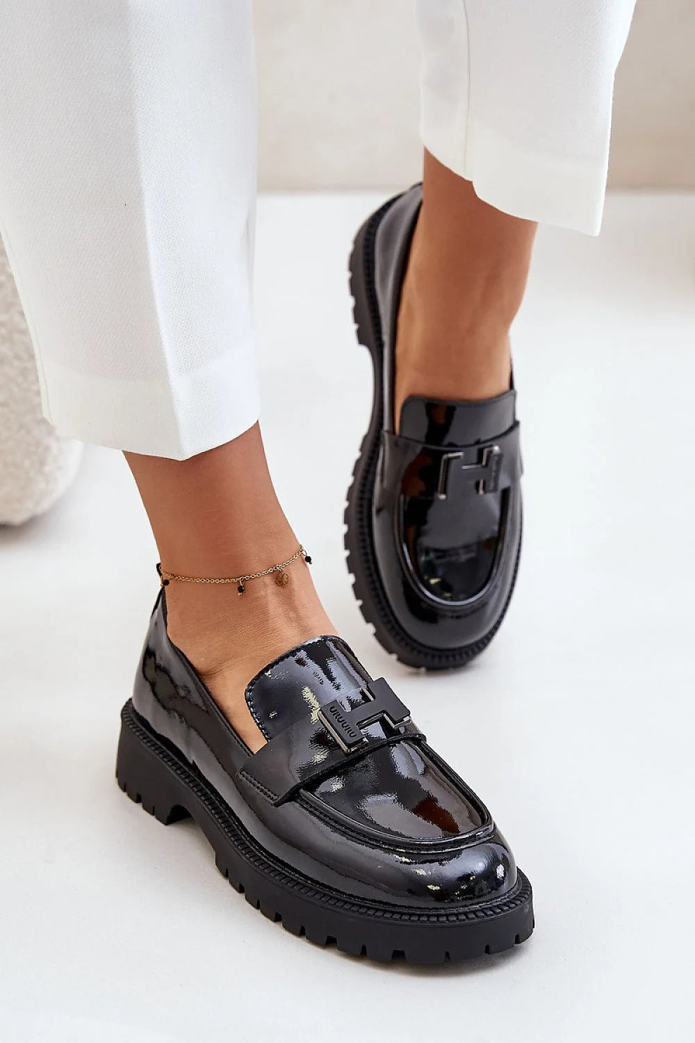 Mocassins femmes élégants cuir verni noir talon plat semelle caoutchouc design moderne finitions luxueuses