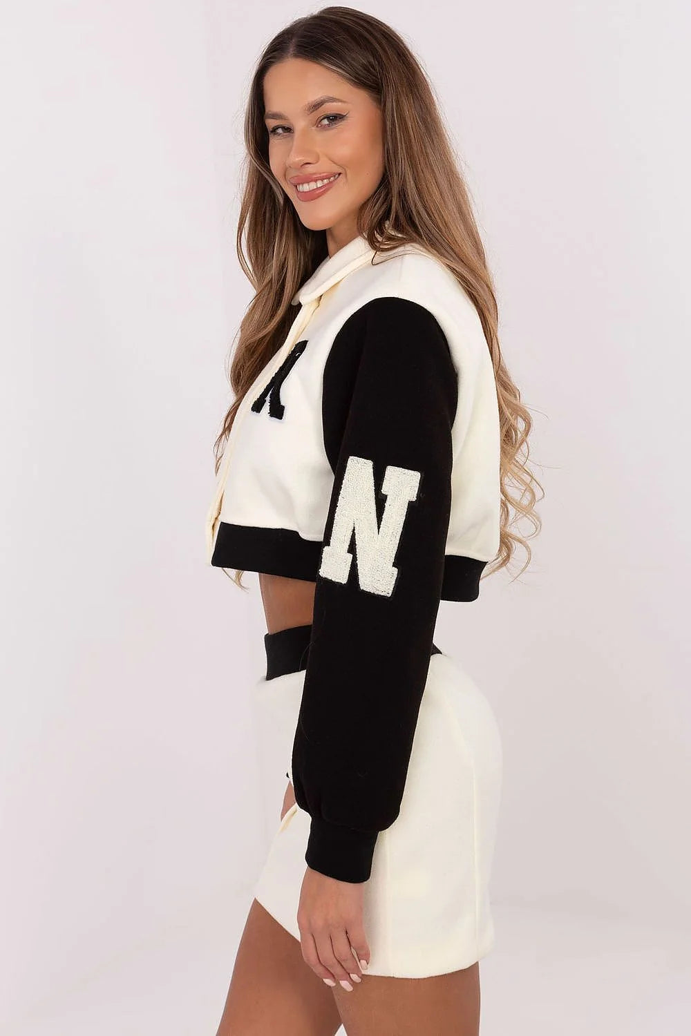 Ensemble varsity pour femme, short ajusté, manches longues, tissu coton polyester, couleurs blanc cassé/noir, finitions métalliques, look sport-chic