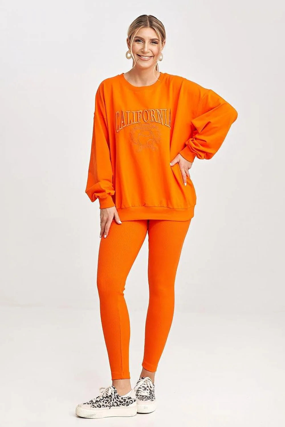 Ensemble sportswear pour femmes, sweatshirt orange, leggings, style casual, confort optimal, vêtement détente, mode moderne, porté quotidien, tenue relax, couleur vif, matière douce, maintien sécurisé, coupe ample, design graphique