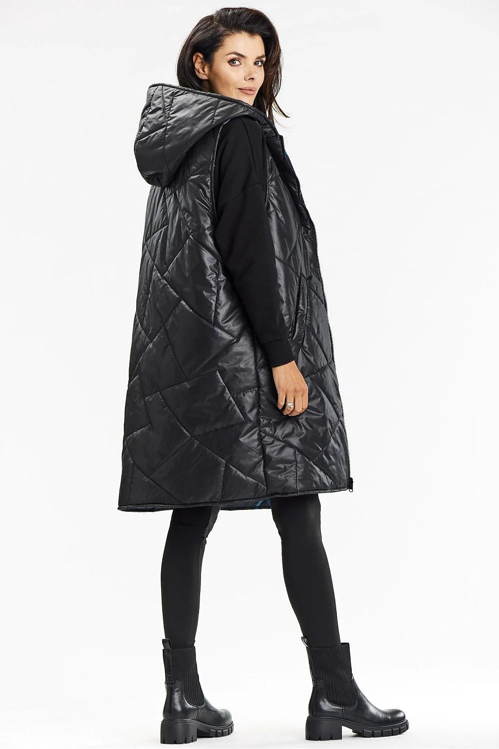 Gilet long sans manches pour femme, design matelassé, capuche intégrée, fermeture éclair centrale, poches latérales, tissu polyester 100%, style moderne et pratique