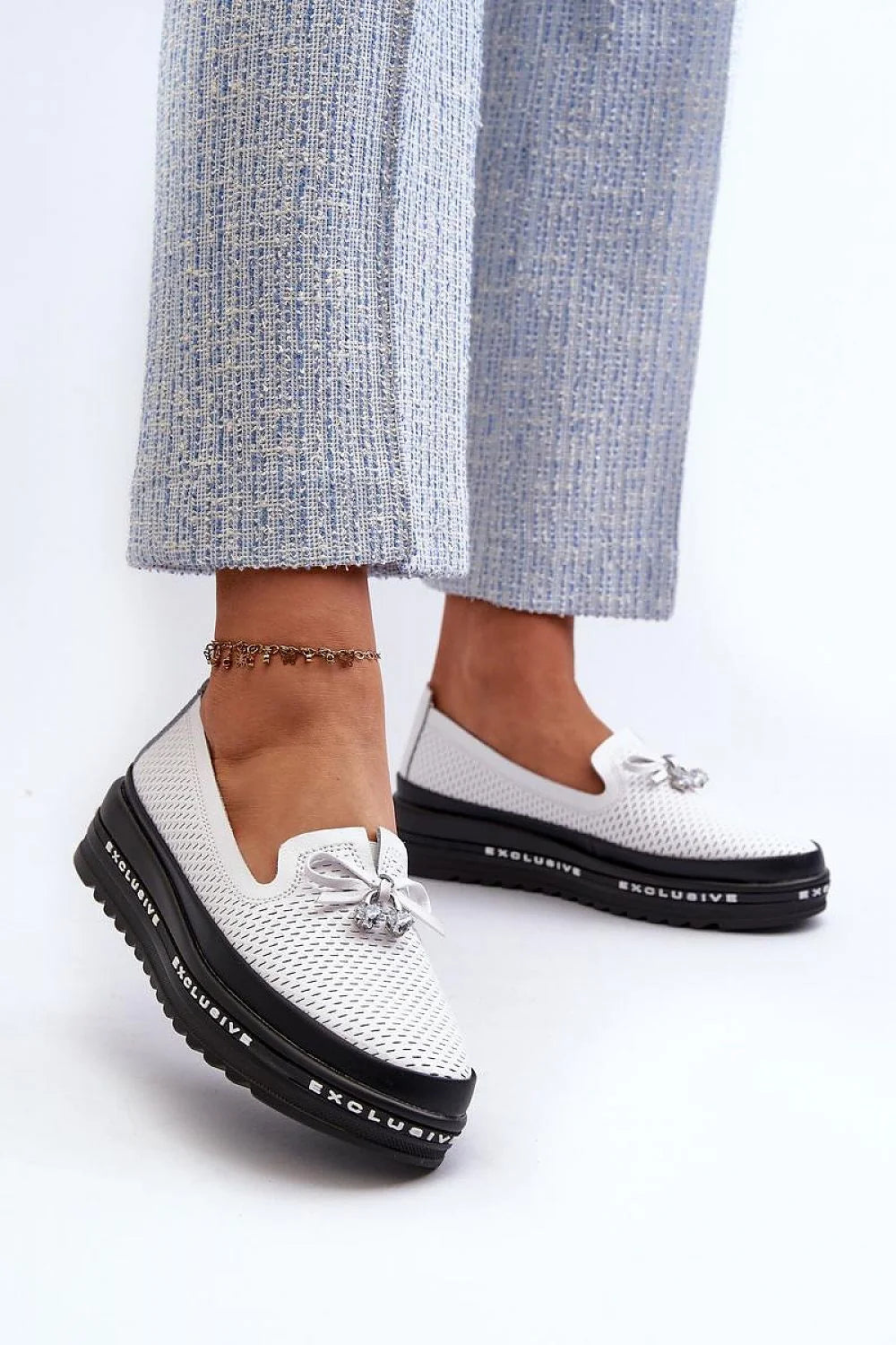 Mocassins pour femmes modernes élégants couleur blanche perforée semelle épaisse nœud décoratif pendentif métallique argenté cuir synthétique tissu technique