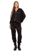 survêtement femme deux pièces veste zippée capuche pantalon jogger noir oversize décontracté zip apparent cordon taillehaute surpiqûre blanche contrastante