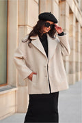 Veste élégante pour femme en laine bouclée beige clair coupe ample manches longues boutons discrets mode urbaine chic hiver automne