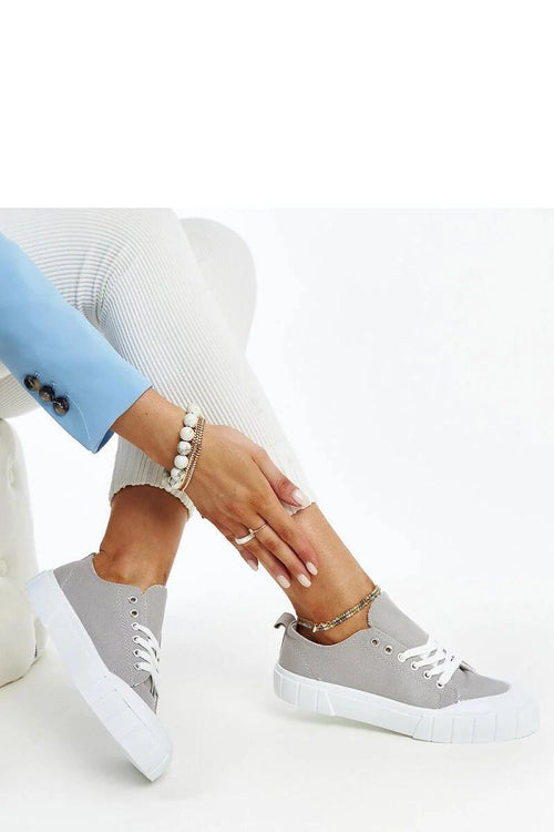 Baskets Adidas grises pour femmes, style moderne, tige basse, toile respirante, semelle caoutchouc, lacets blancs, accessoire chaînette multicolore, sneakers confortables occasionnels, look décontracté et sophistiqué