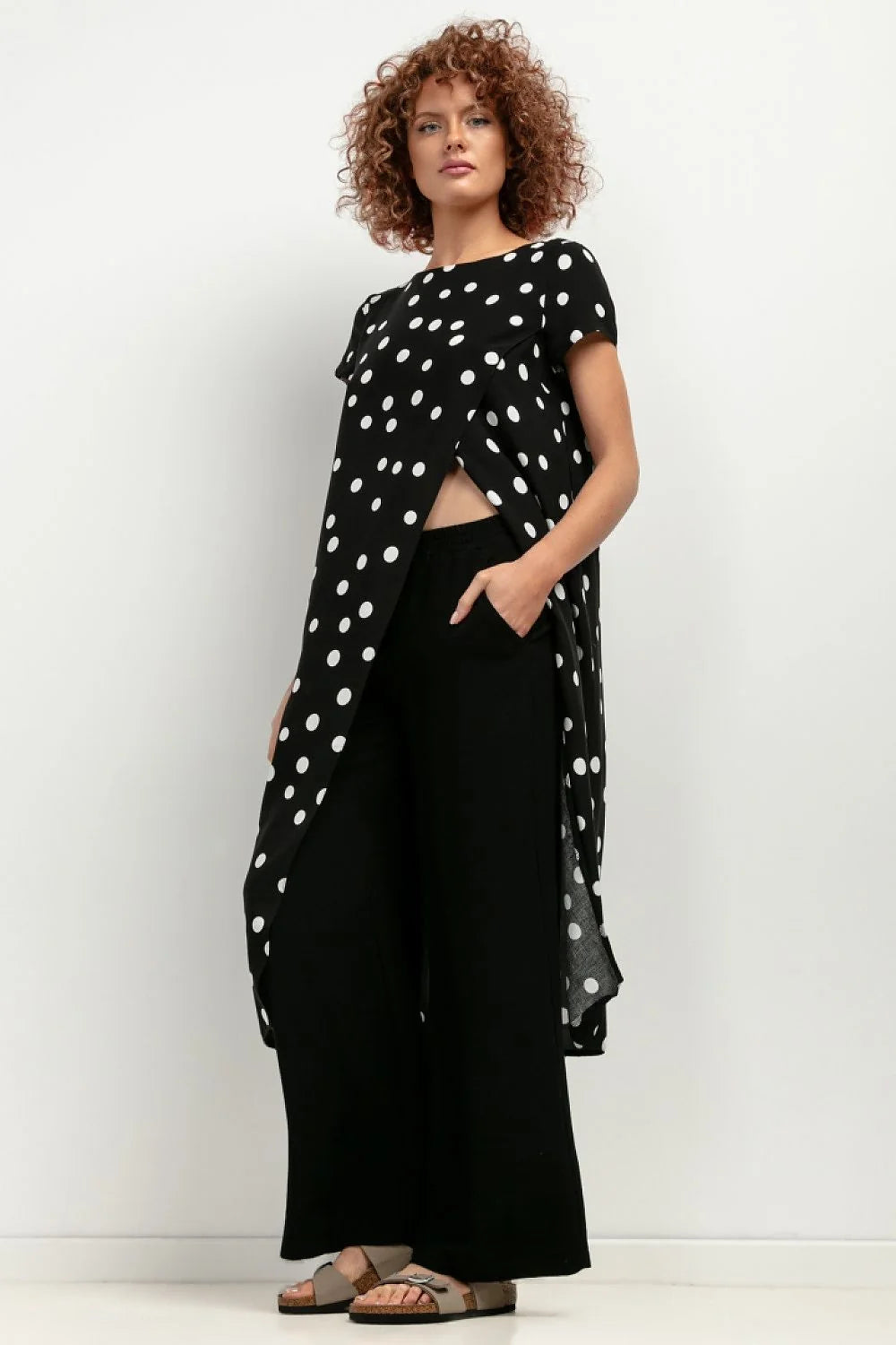 Tenue féminine contemporaine deux pièces haut asymétrique noir pois blancs pantalon blanc large femmes mode été 2023