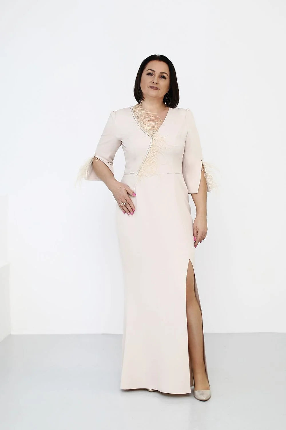 robe soirée longue fourreau ajustée nude rosé décolleté V asymétrique manches troisquarts fentes plumes frangées fente latérale haute