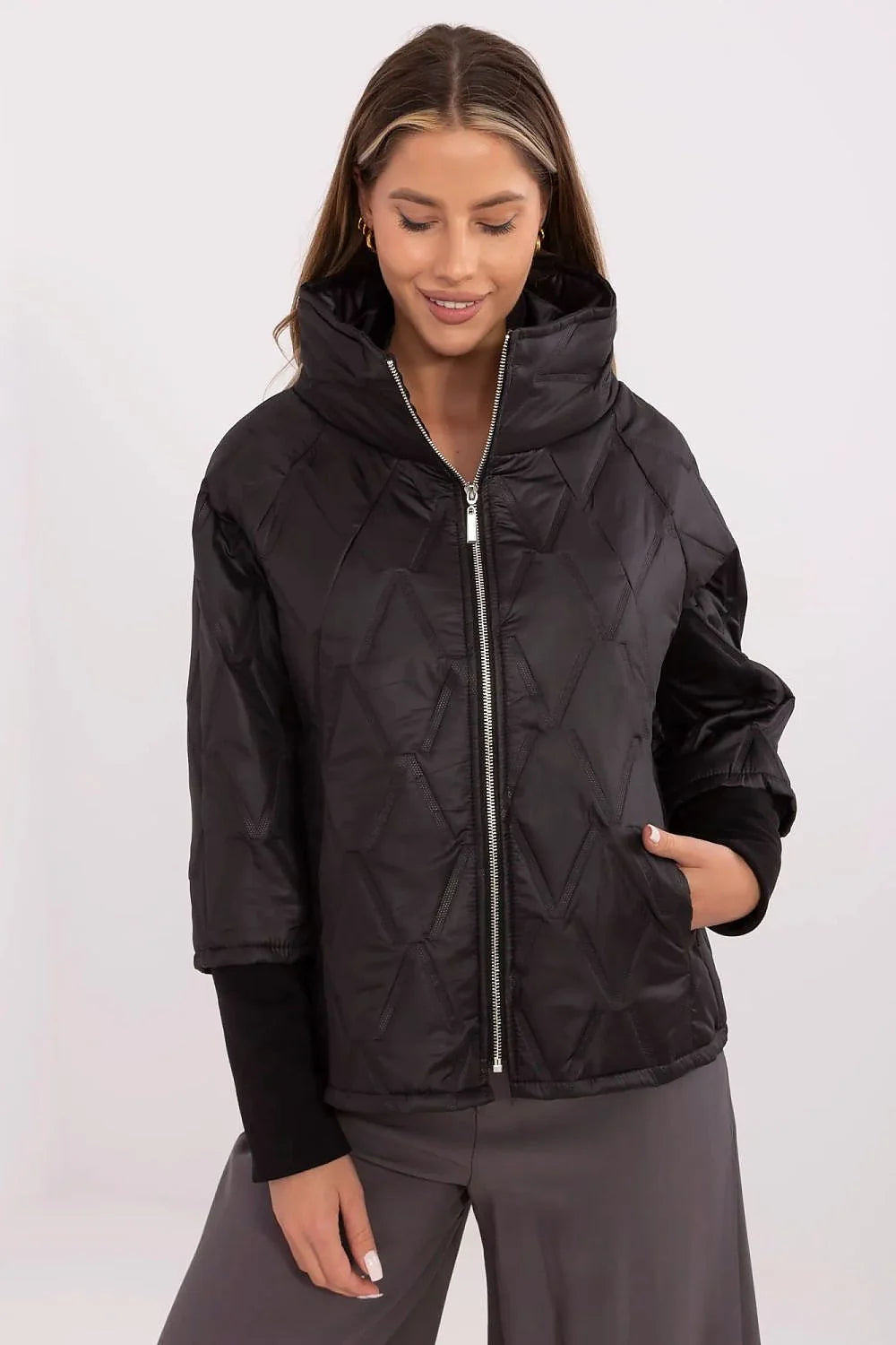 Veste courte femme design moderne épuré couleur noire tissu synthétique brillant motifs géométriques relief col montant fermeture éclair métallique poches latérales manches 3/4