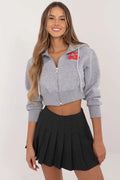 sweatshirt capuche court zippé gris chiné doux logo rouge cordon serrage manches longues bouffantes jupe plissée noire taille haute élégant