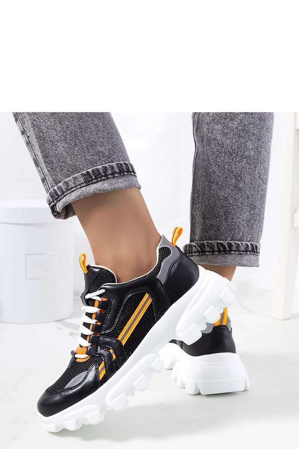 Baskets sportives modernes pour femmes en cuir synthétique et mesh noir, accents orange, semelle épaisse blanche, style chunky, confortable et élégante