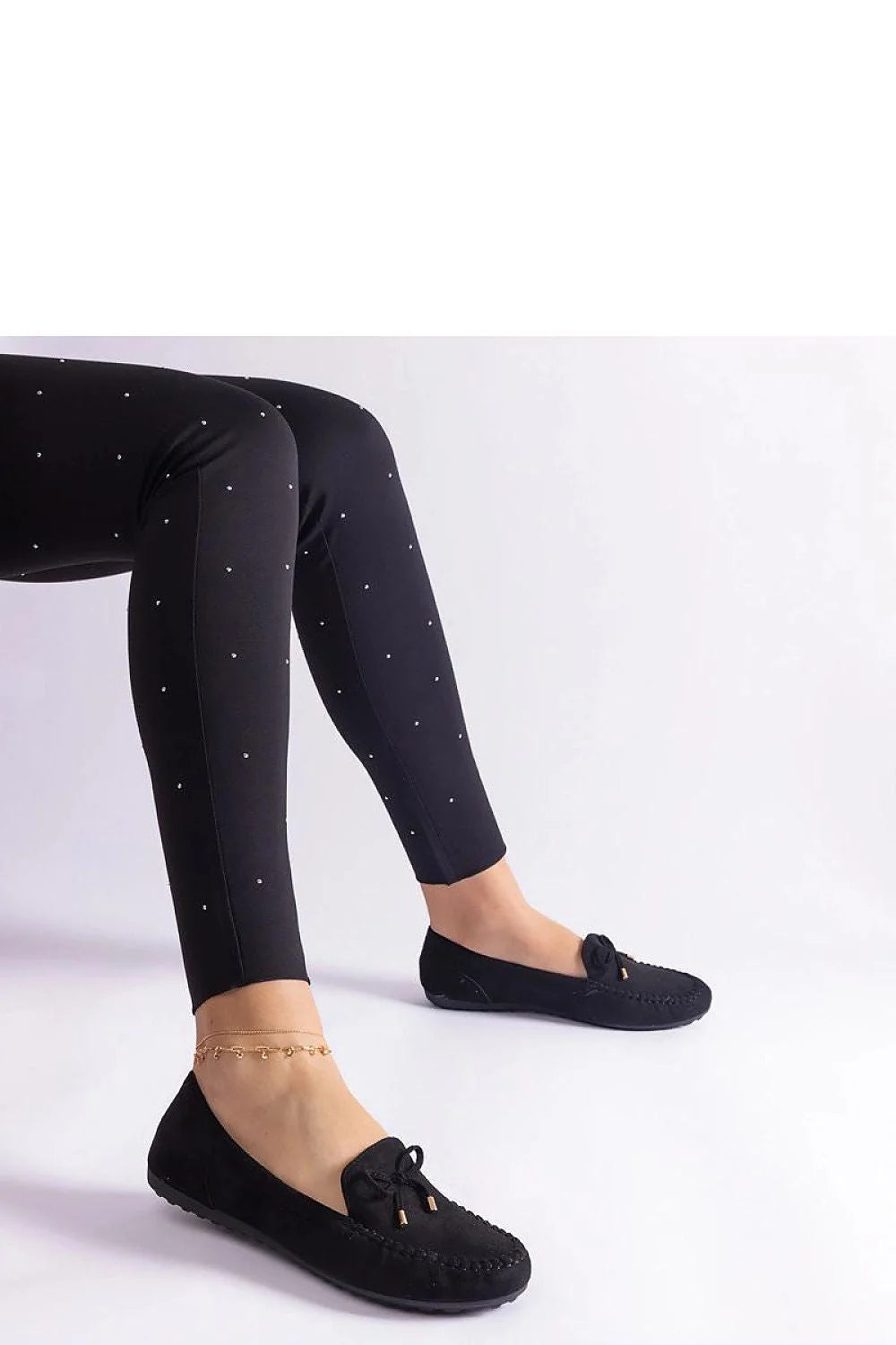 Tenue élégante pour femme pantalon slim ajusté et mocassins noirs en cuir avec détails métalliques et motifs strass