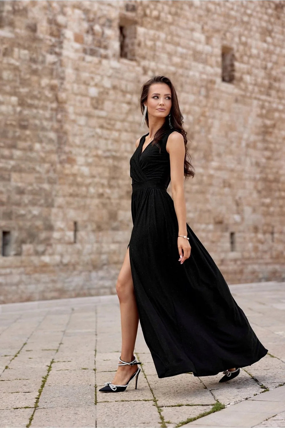 Robe de soirée longue sans manches V croisé fente haute robe noire scintillante épaules mises en valeur sandales talons femme