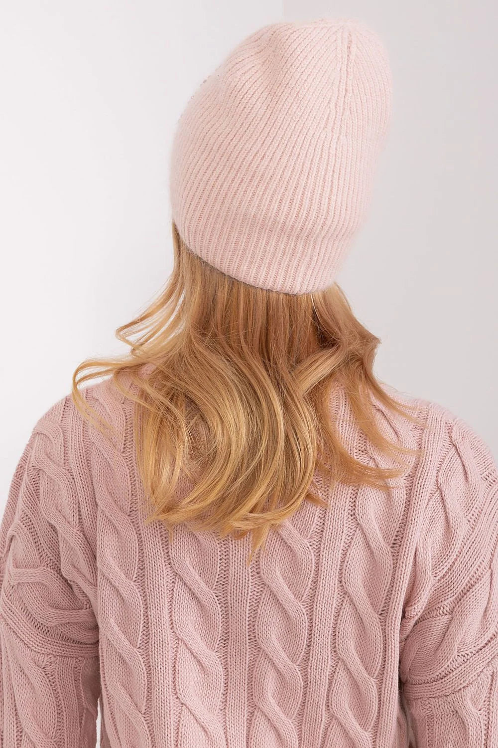 Ensemble hiver féminin bonnet pull maille torsadée rose pâle matières chaudes style moderne élégant
