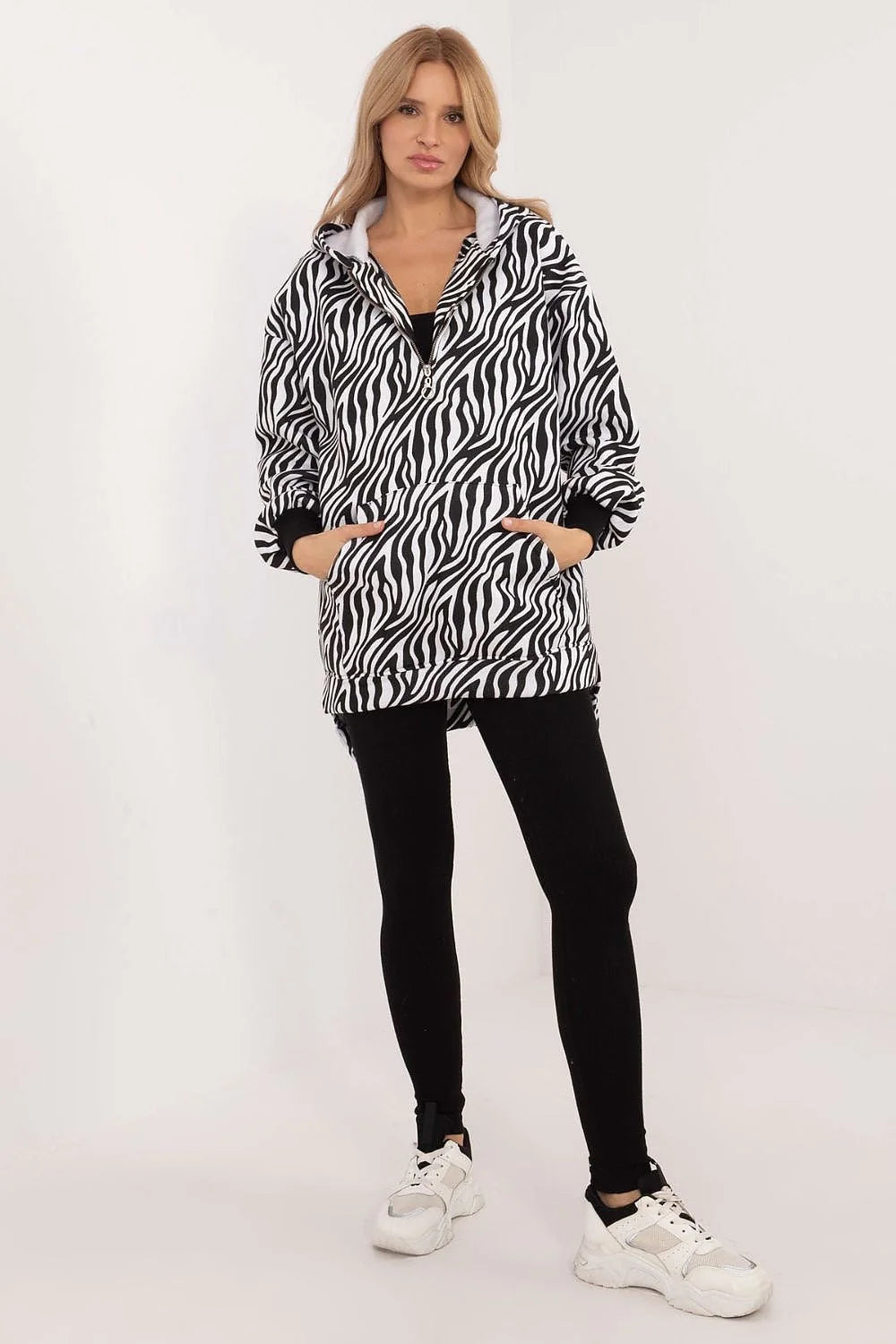 Veste zébrée audacieuse avec leggings noirs et sneakers blanches mode femme confortable