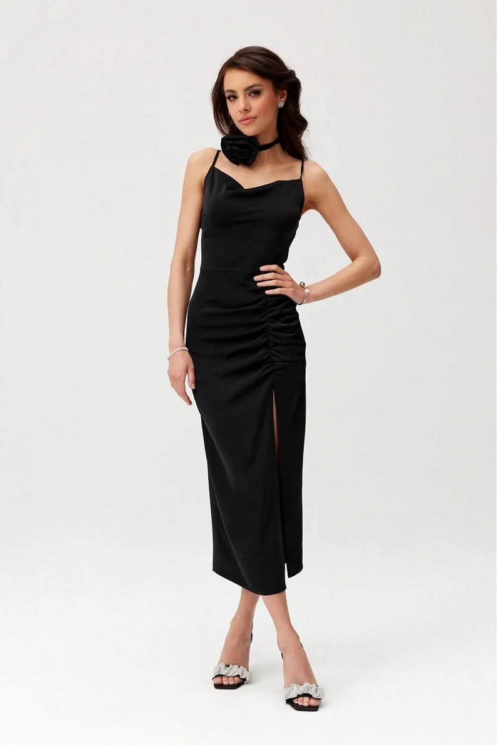 Robe de cocktail élégante noire longueur midi dos nu bretelles fines tissu satiné fente jambe fleur accessoire femme