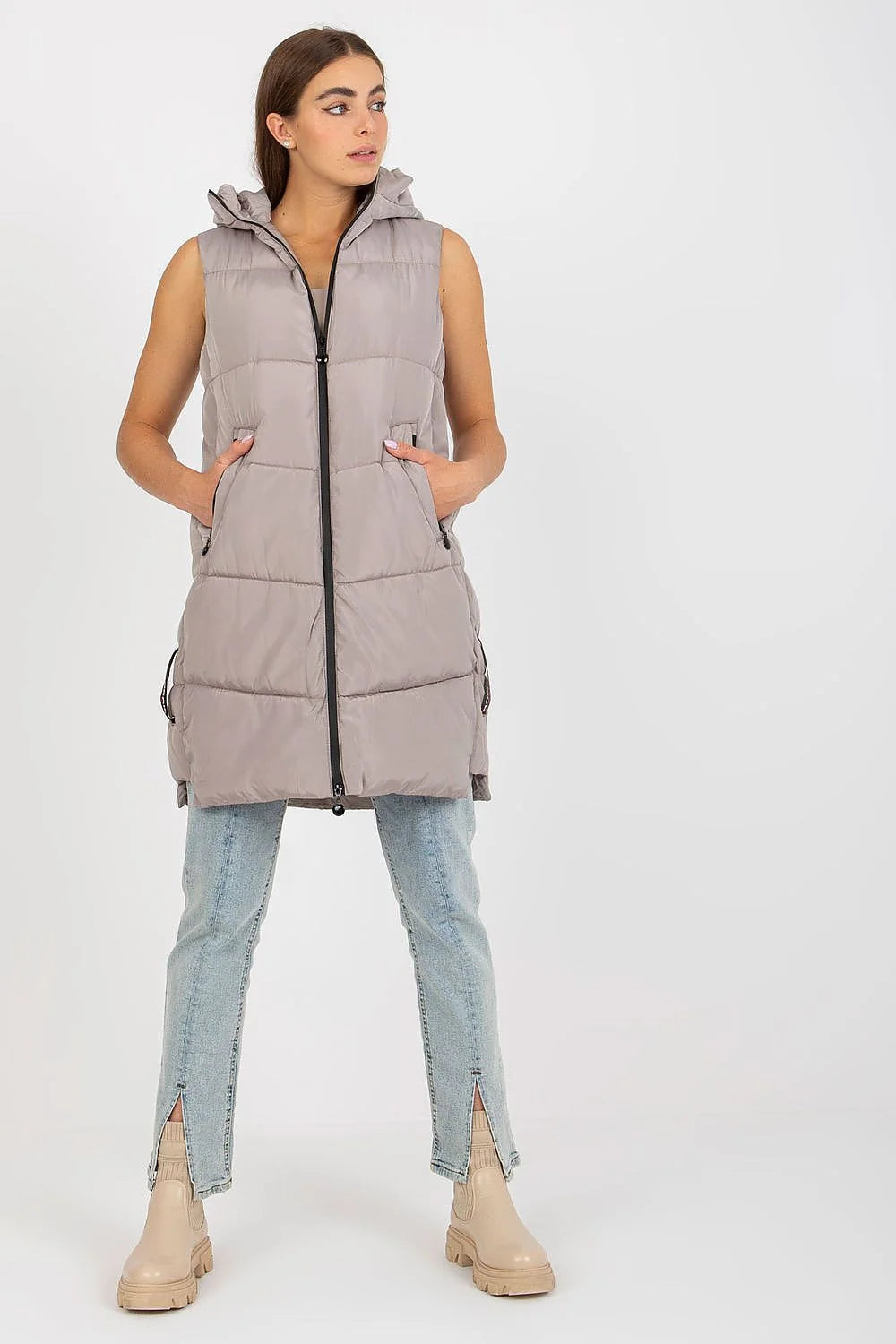 Gilet doudoune pour femme en polyester matelassé couleur taupe, coupe longue, sans manches, capuche ajustable et poches latérales
