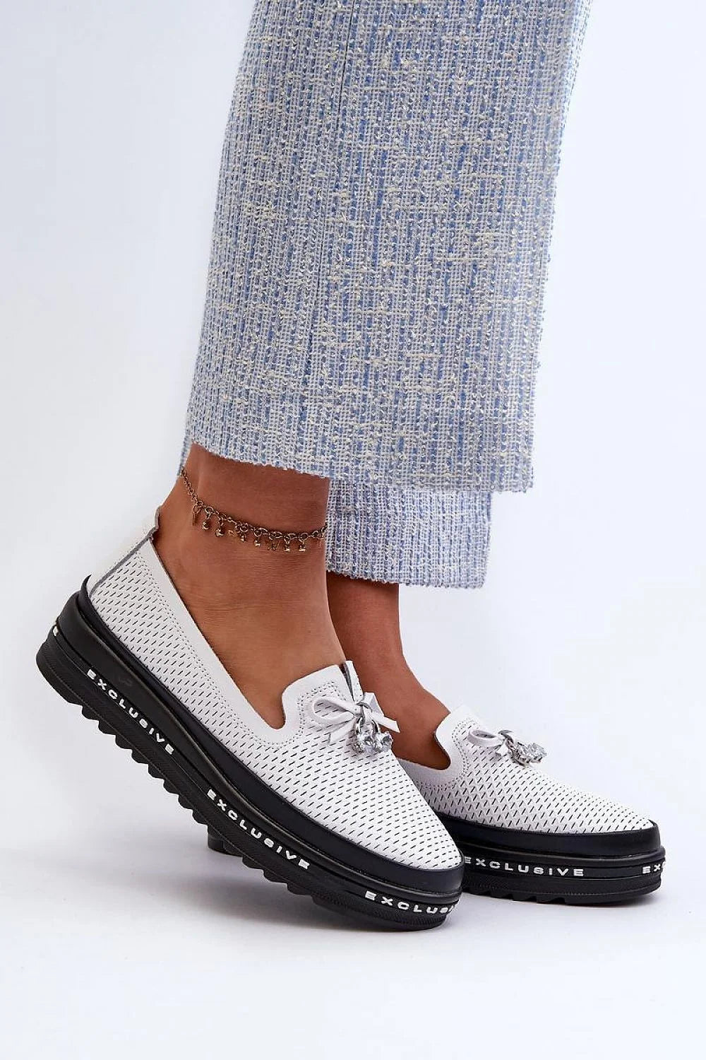 Mocassins pour femmes modernes élégants couleur blanche perforée semelle épaisse nœud décoratif pendentif métallique argenté cuir synthétique tissu technique