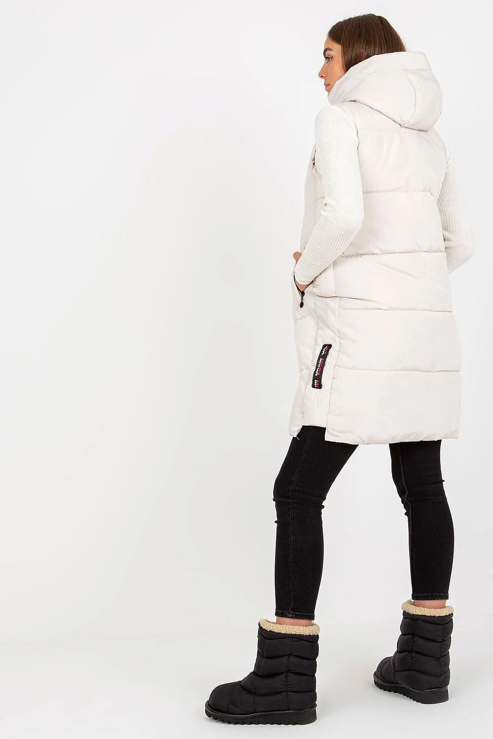 Gilet doudoune pour femme en polyester matelassé couleur taupe, coupe longue, sans manches, capuche ajustable et poches latérales