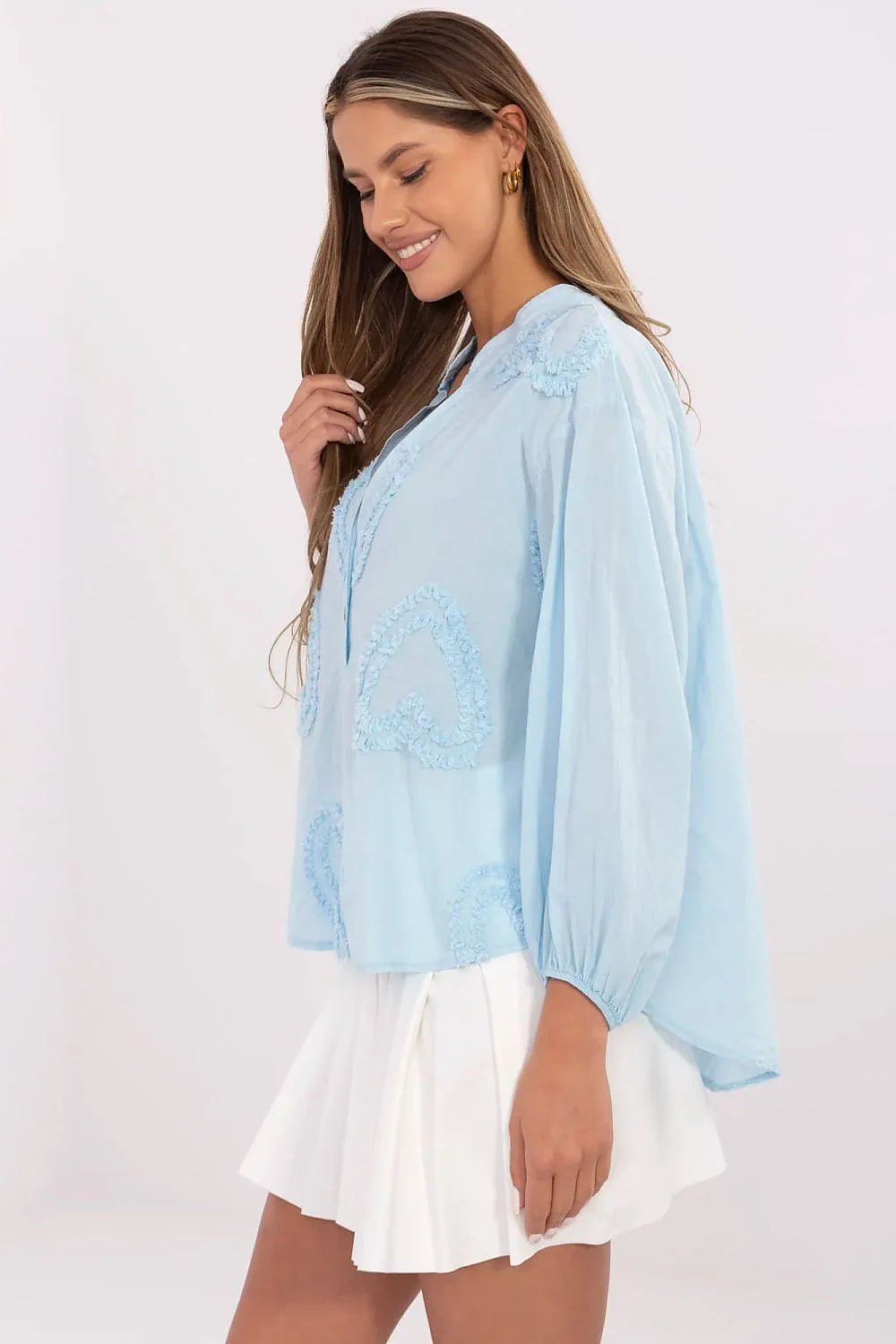 Chemisier bleu clair brodé romantique avec manches longues élastiquées, jupe blanche plissée, tenue élégante pour femme