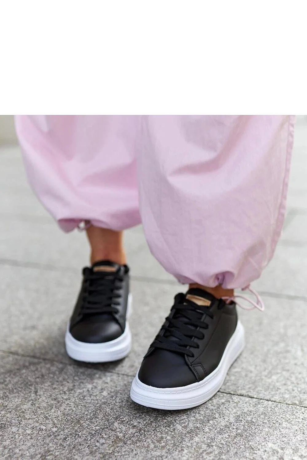 Baskets mode femmes cuir noir semelle épaisse blanche design minimaliste style sophistiqué confortable lacets noirs détails métalliques dorés
