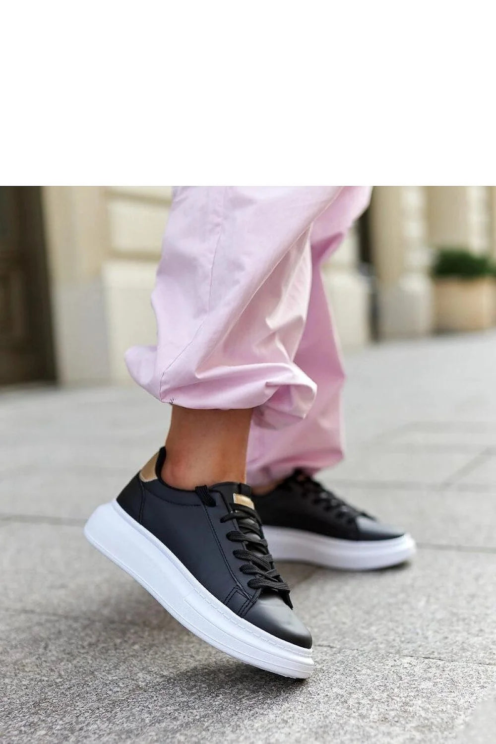 Baskets mode femmes cuir noir semelle épaisse blanche design minimaliste style sophistiqué confortable lacets noirs détails métalliques dorés