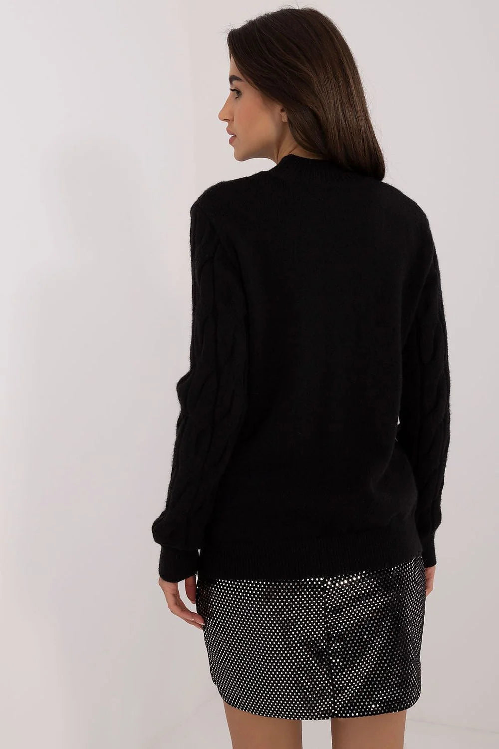 Pull torsadé en laine côtelé noir manches longues col roulé associé à jupe noire à pois argentés polyester femme
