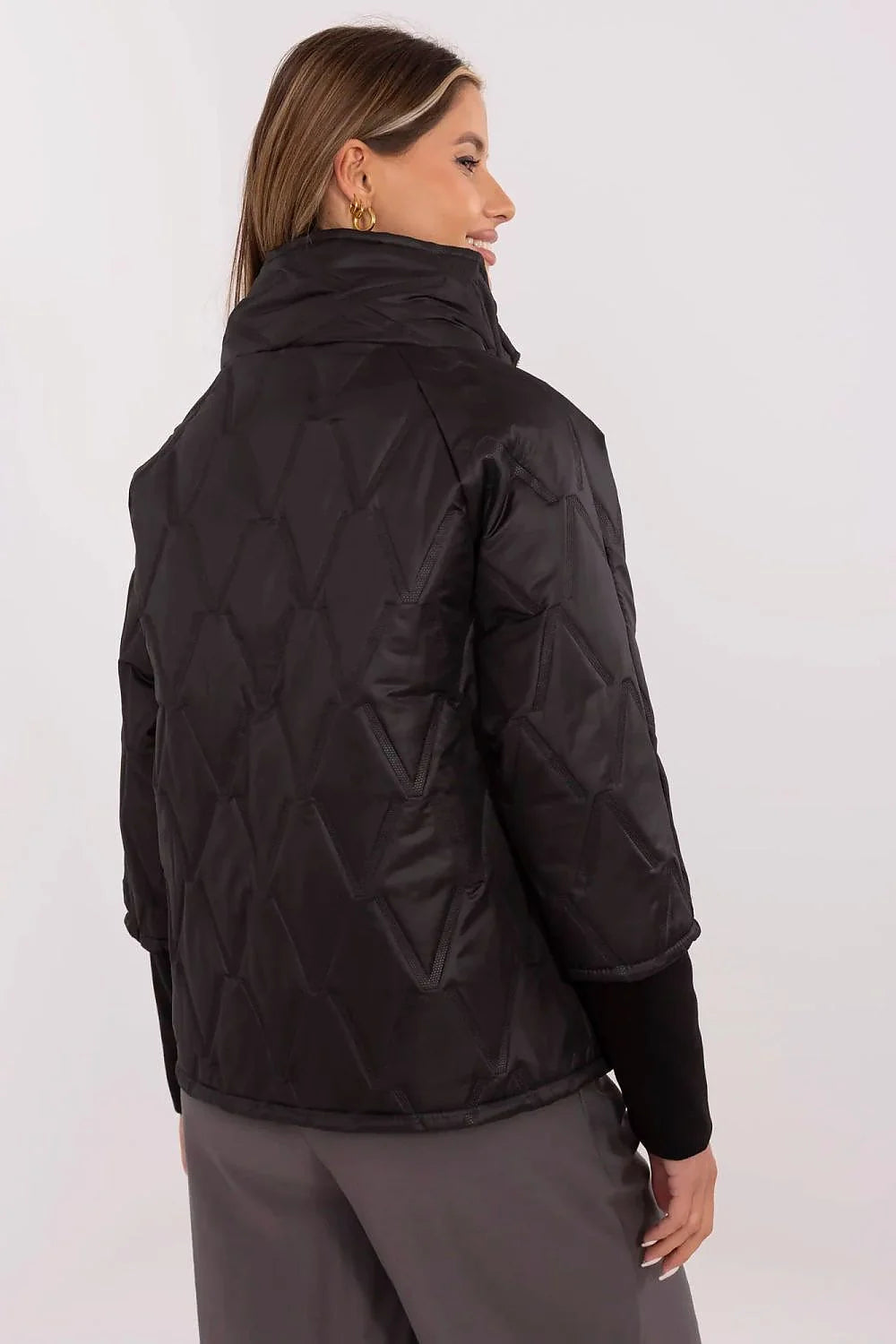 Veste courte femme design moderne épuré couleur noire tissu synthétique brillant motifs géométriques relief col montant fermeture éclair métallique poches latérales manches 3/4