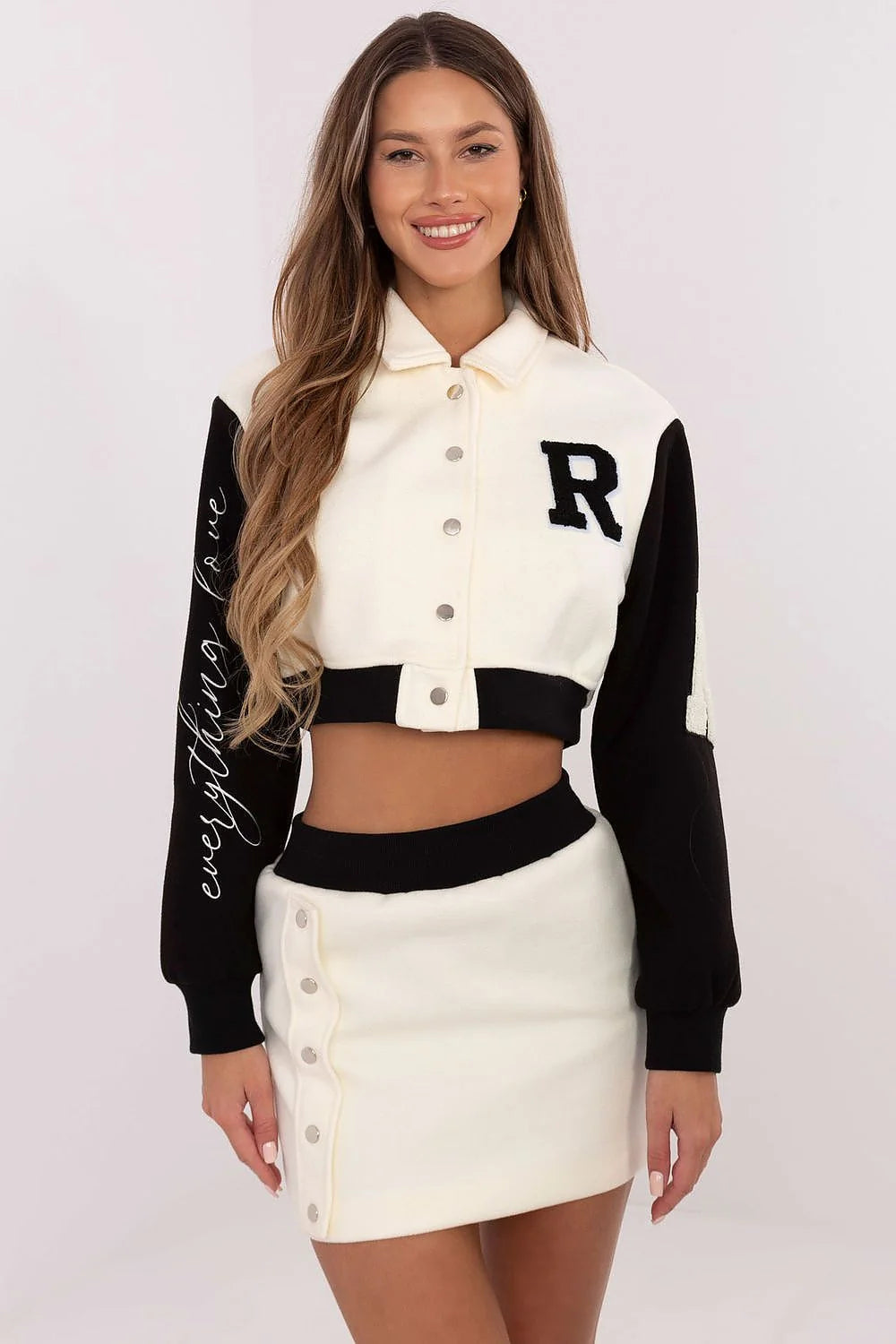 Ensemble varsity pour femme, short ajusté, manches longues, tissu coton polyester, couleurs blanc cassé/noir, finitions métalliques, look sport-chic