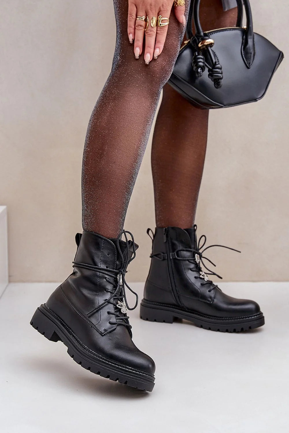bottines cuir écologique noir bout arrondi lacets pendentif métallique zip latéral broches doublure fourrure synthétique semelle crantée antidérapante talons plats