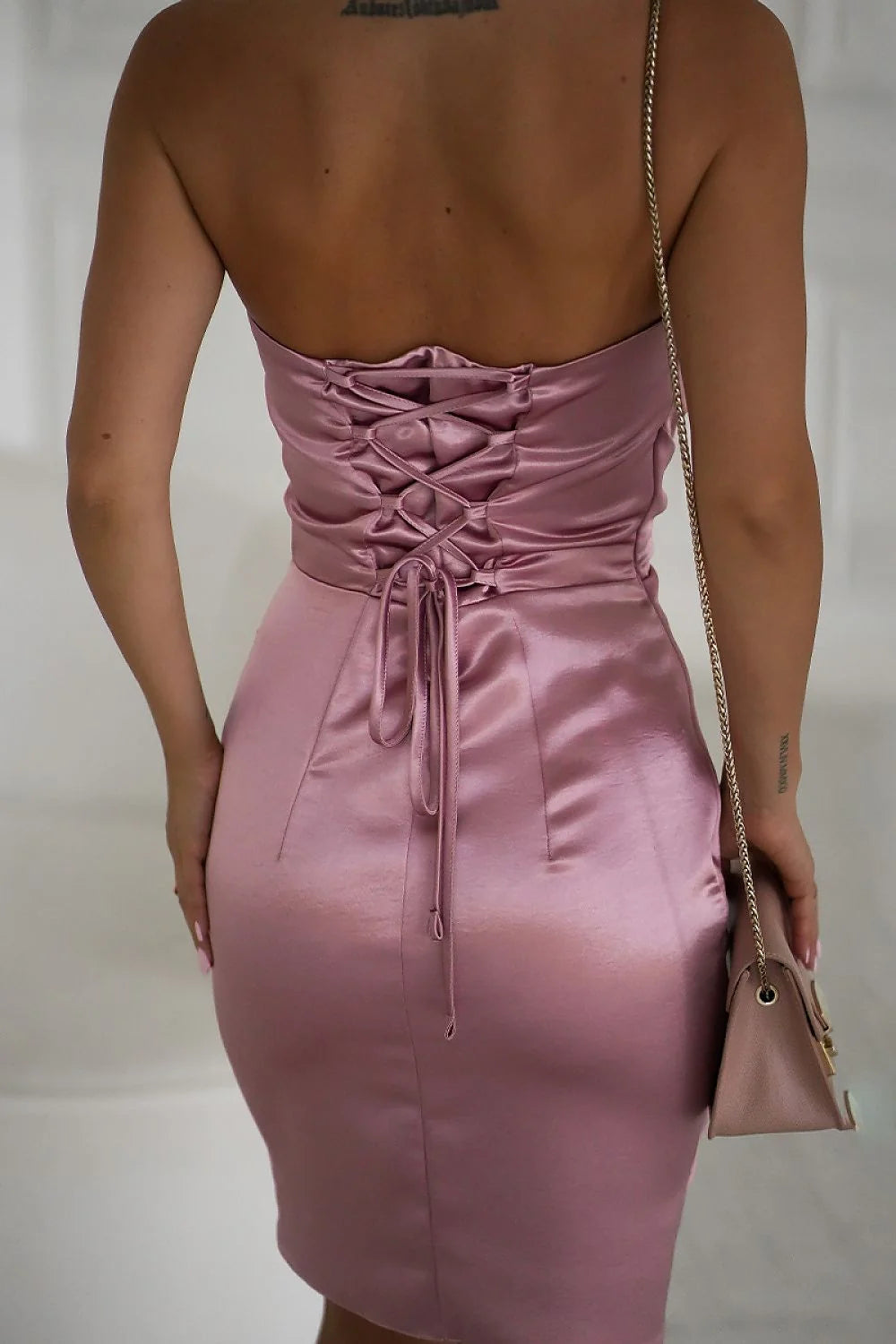 robe courte moulante satin brillant rose poudré fines bretelles chaîne rosette drapée buste coupe ajustée cintrée fronces latérales ourlet asymétrique
