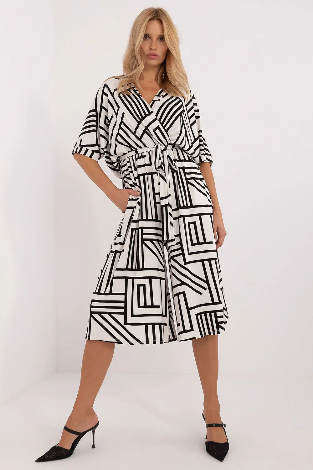 Robe féminine design moderne graphique motif géométrique couleurs contrastantes coupe midi ceinture ajustable manches trois quarts poches latérales vêtement versatile occasion formelle décontractée
