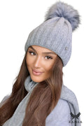 Bonnet Kamea en laine haute qualité pour femme, design élégant, intemporel, pompon moelleux, couleur grise, ajusté, structure moderne, logo métal, accessoire mode hiver
