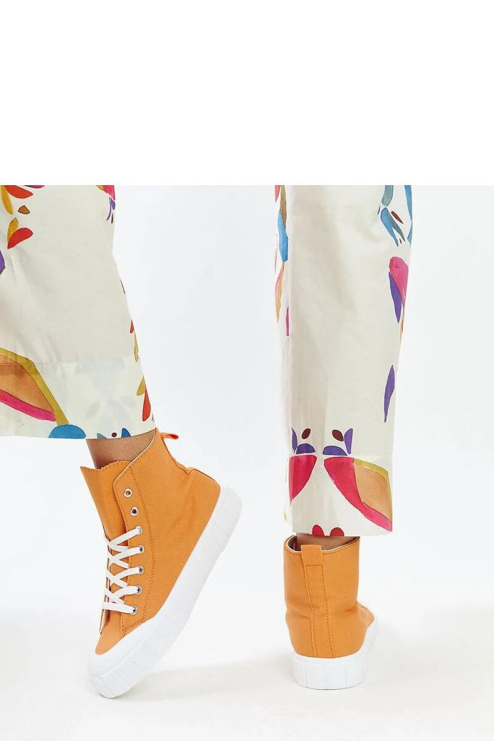 Baskets montantes à lacets design moderne couleur orange vif pour femmes, sac à main en simili cuir beige, pantalon long à motifs abstraits multicolores, montre dorée et bracelet en perles blanches