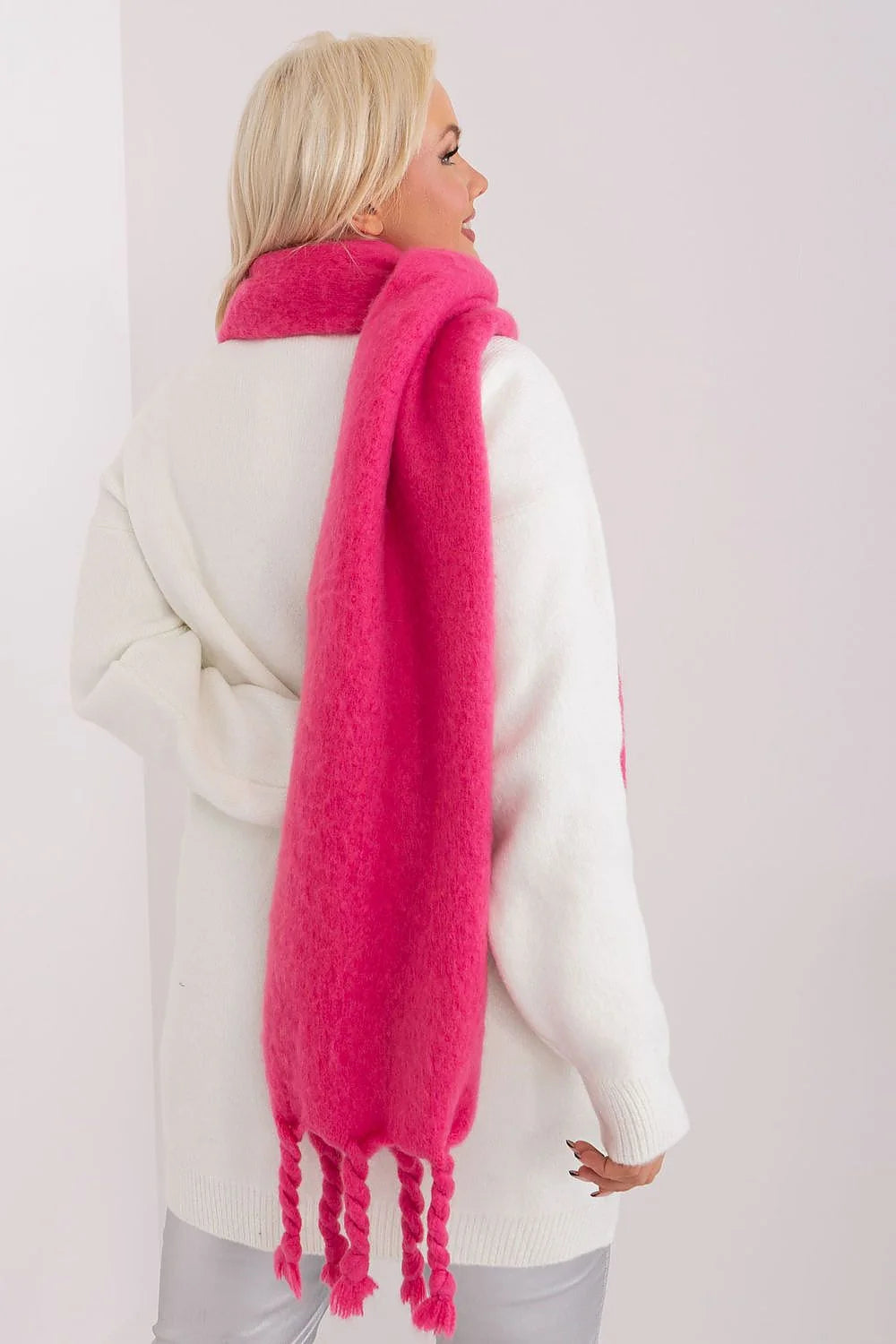 Écharpe longue en mohair rose vif avec franges tressées, assortie à un pull blanc côtelé, mode automne/hiver pour femme