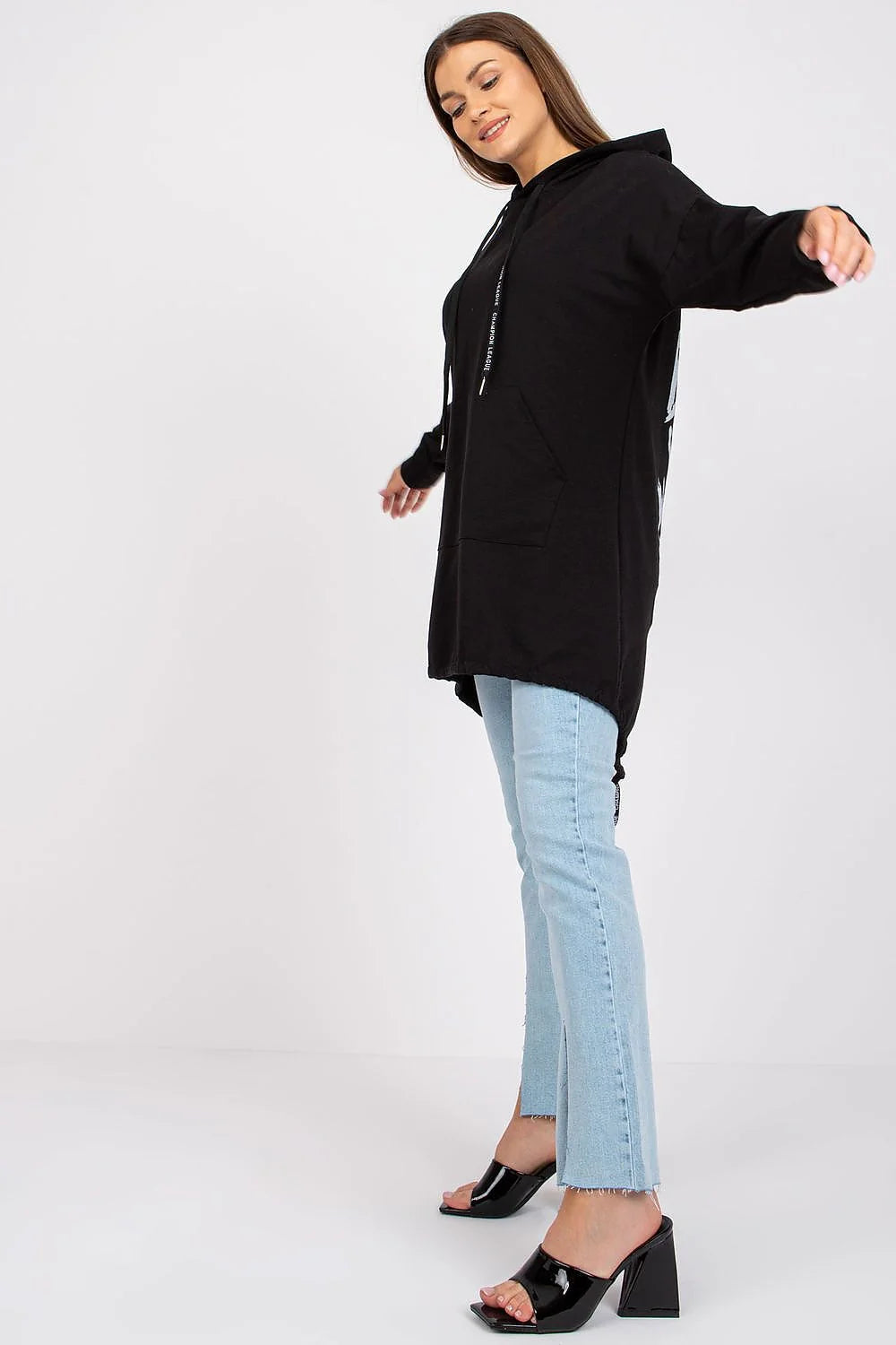 Sweatshirt à capuche noir long style décontracté pour femmes avec jeans bleu clair et sandales noires talons hauts mode casual