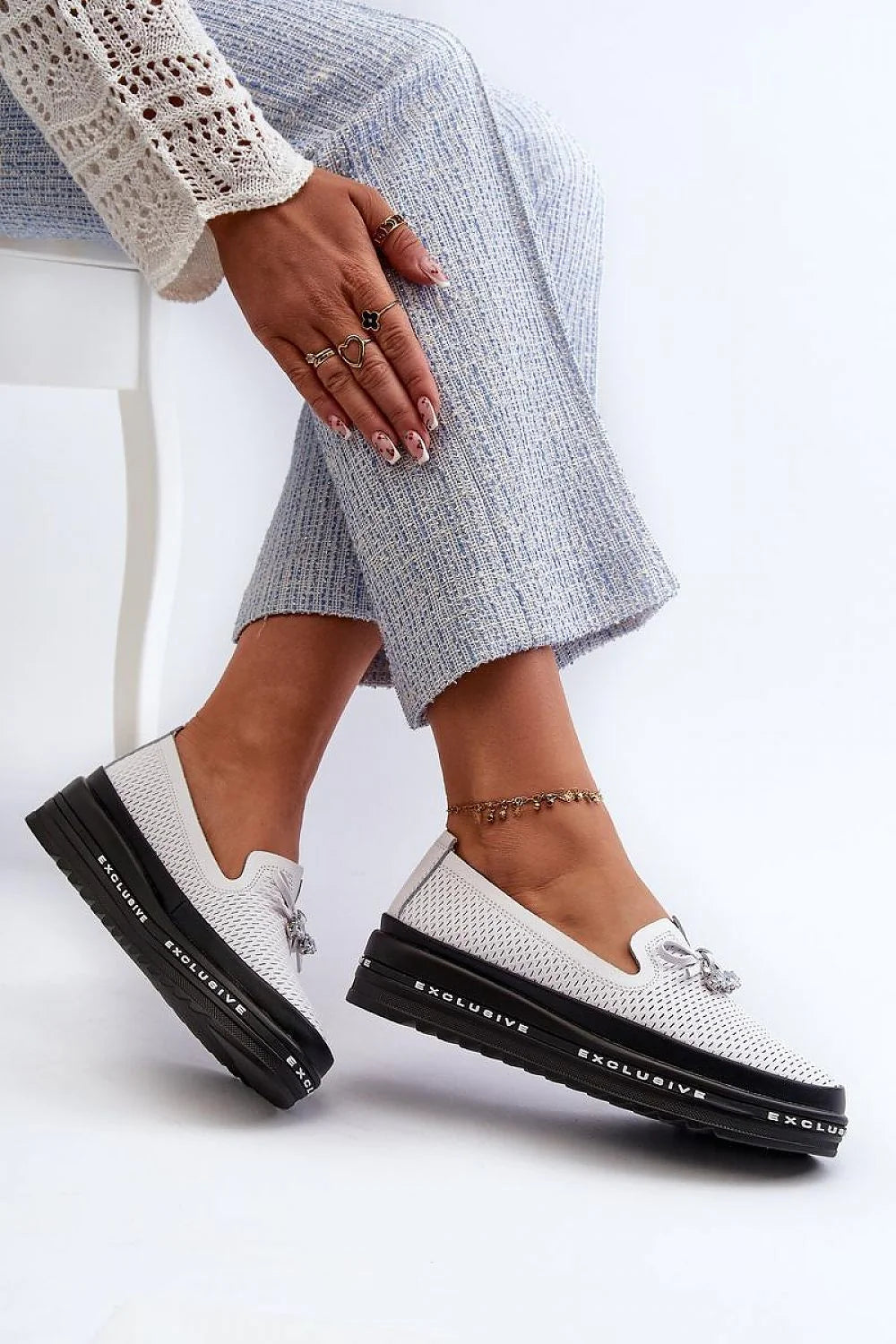 Mocassins pour femmes modernes élégants couleur blanche perforée semelle épaisse nœud décoratif pendentif métallique argenté cuir synthétique tissu technique