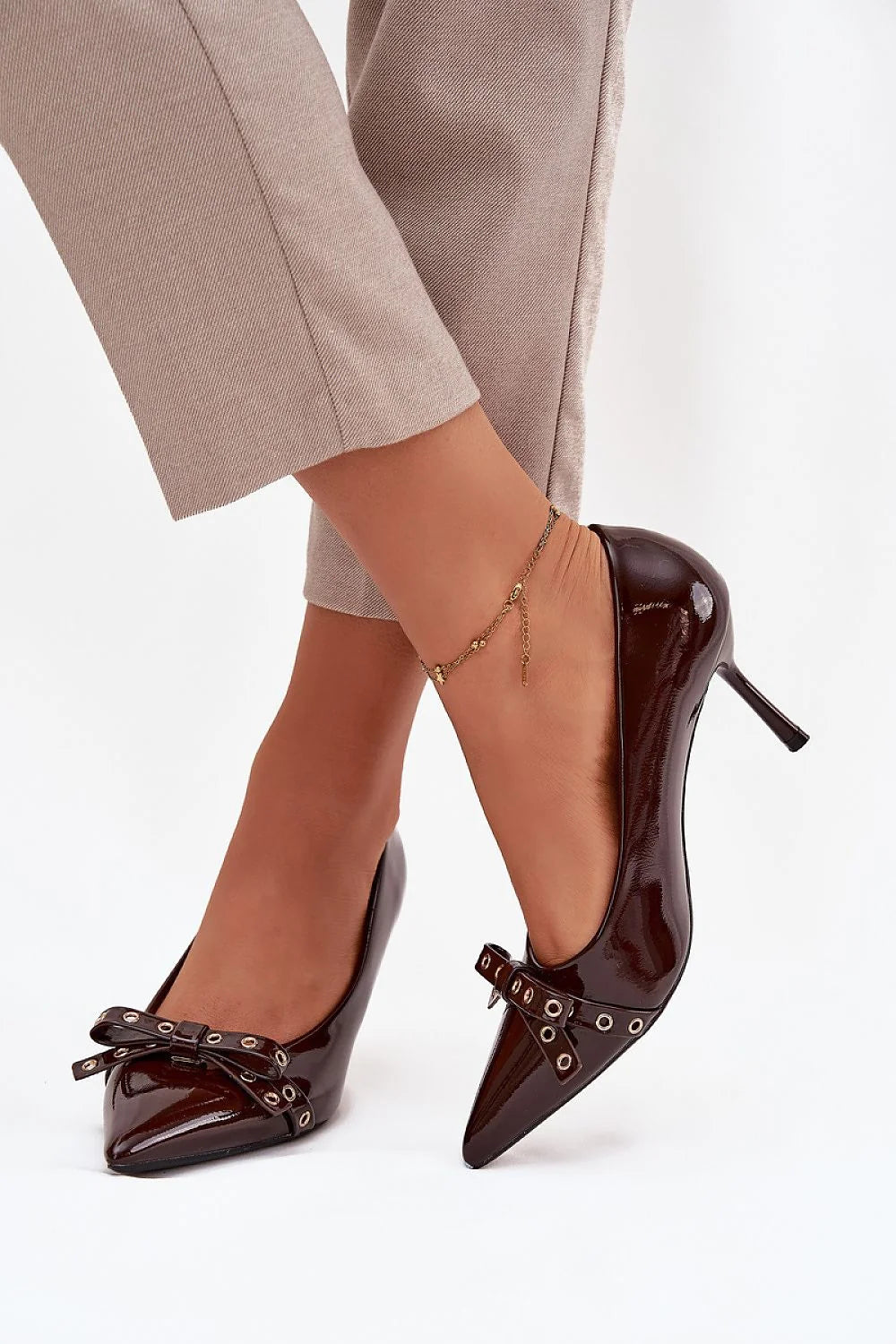escarpins vernis marron foncé bout pointu talon aiguille élégant chic féminin mince nœud décoratif œillets métalliques slipon empeigne basse brillante