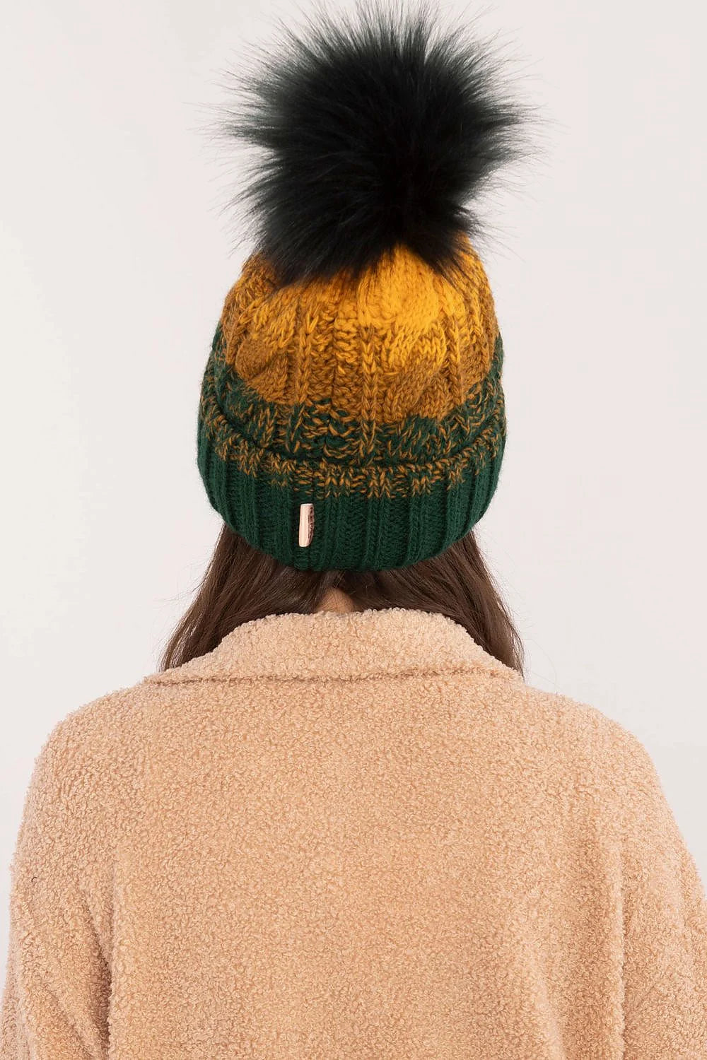 Bonnet tricoté pour femme couleur verte foncée et moutarde, motif écossais, pompon fourrure noire, doublure polaire, style hivernal élégant, coupe classique, matières chaudes et confortables