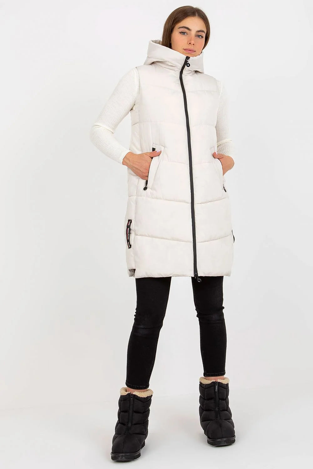 Gilet doudoune pour femme en polyester matelassé couleur taupe, coupe longue, sans manches, capuche ajustable et poches latérales