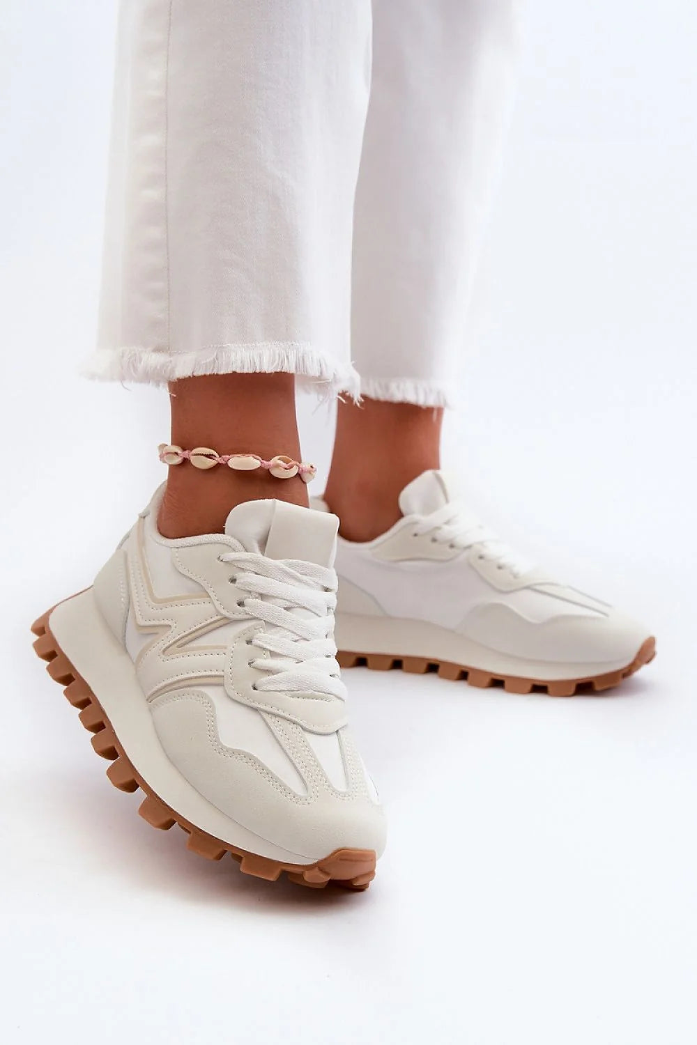 Chaussures de sport pour femmes design moderne coupe basse matériau synthétique cuir imitation lacets blancs semelle marron style sport-chic confort