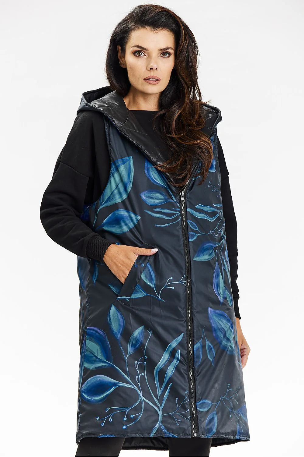 Gilet long sans manches pour femme, design matelassé, capuche intégrée, fermeture éclair centrale, poches latérales, tissu polyester 100%, style moderne et pratique