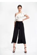 ensemble asymétrique chemisier volant épaule unique haut ajusté pantalon large fluide ceinture haute nouée fentes ourlet midi contraste noir blanc